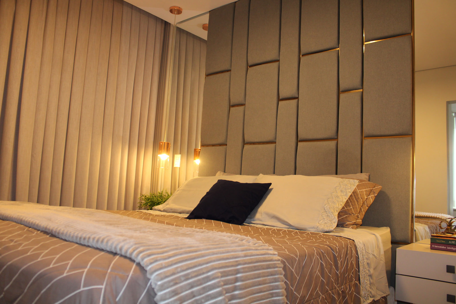 Suíte casal elegante com projeto de interiores personalizado em Curitiba — conforto, texturas e iluminação acolhedora.